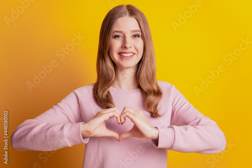 Photo of romantic lady gesturing heart figure toothy smile on yellow background
