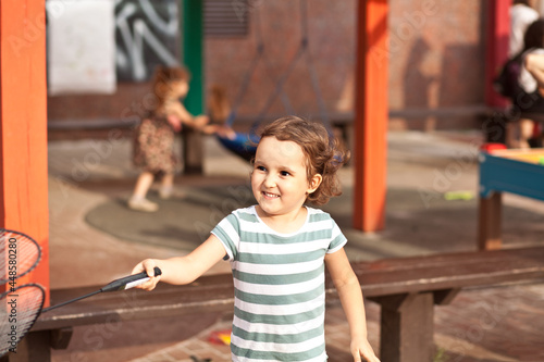 Little adorable girl playing badminton active outdoor game