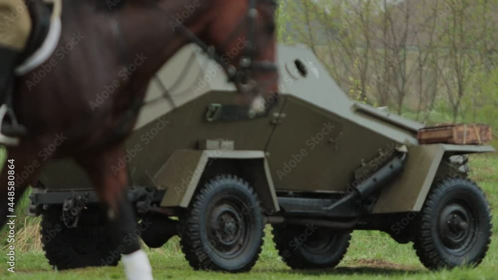 Red Army soviet armored car and rider on horse ride on field during ...
