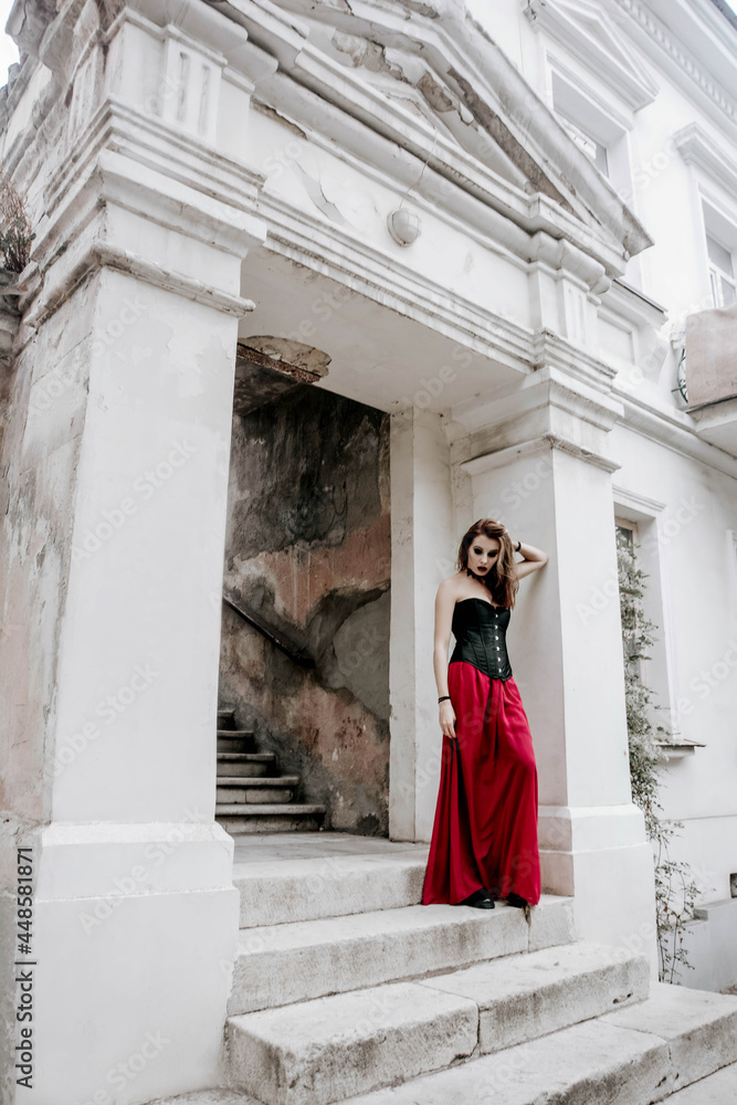 Halloween witch woman with snow-white skin beautiful with makeup in a black corset and a red dress Halloween witch woman with snow-white skin beautiful with makeup in a black corset and a red dress