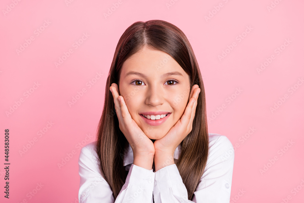 Photo of young school girl happy positive smile hands touch cheeks pupil dream isolated over pink color background Photo of young school girl happy positive smile hands touch cheeks pupil dream isolated over pink color background