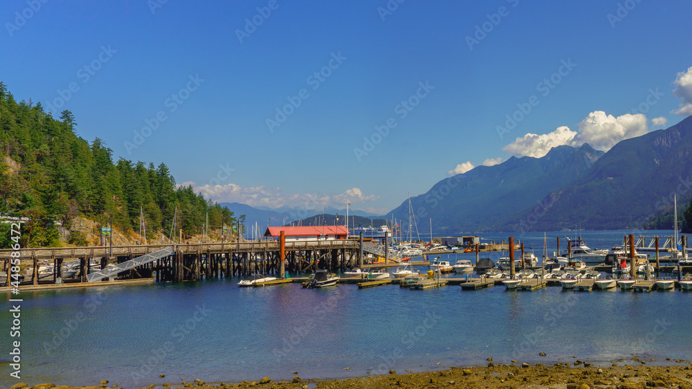Spectacular ocean, mountain and forest scenery viewed from Horseshoe Bay marina, BC, mid-summer with departing ferry visible in background
