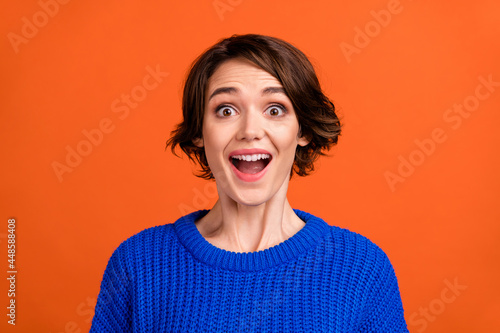 Photo of cool brunette hair young lady wear blue sweater isolated on orange color background