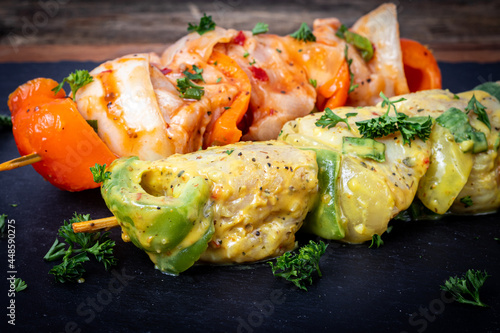 Raw chicken skewers in marinade with spices and herbs