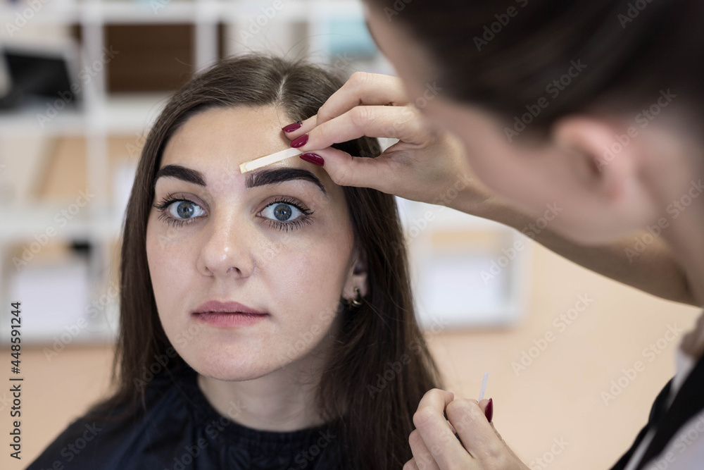 Painless removal of a wax strip over the eyebrows to remove excess hairs. Waxing at the master. Painless removal of a wax strip over the eyebrows to remove excess hairs. Waxing at the master.