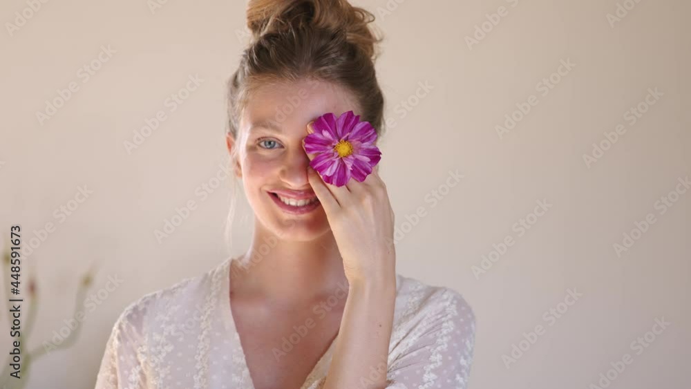 Beautiful woman covering eyes with purple flowers Beautiful woman covering eyes with purple flowers