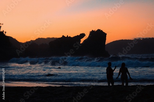 Sillhouette of a couple enjoy the sunset in the beach