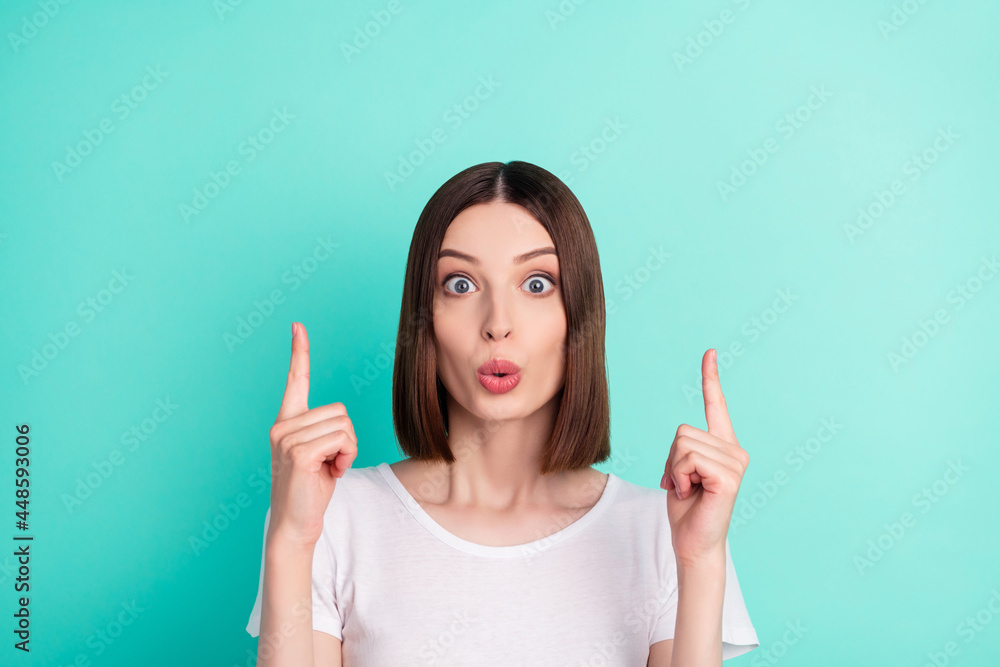 Portrait of attractive amazed brown-haired girl demonstrating up copy space ad isolated over bright teal turquoise color background Portrait of attractive amazed brown-haired girl demonstrating up copy space ad isolated over bright teal turquoise color background