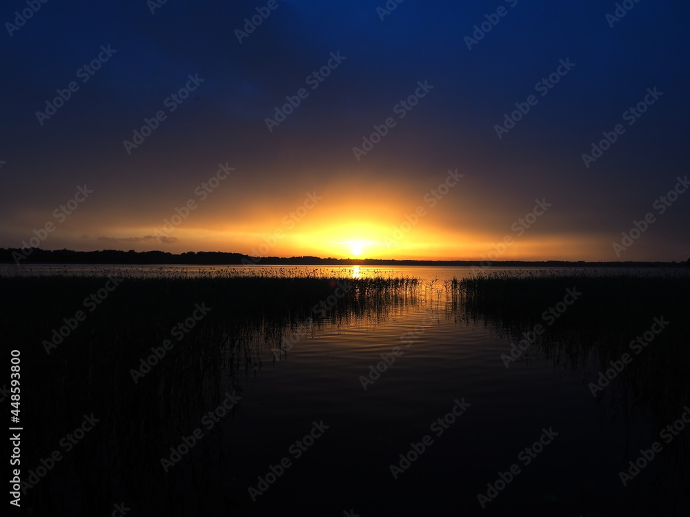 Sunset sky and water. Peaceful evening. Reed silhouettes. Travel and leisure
