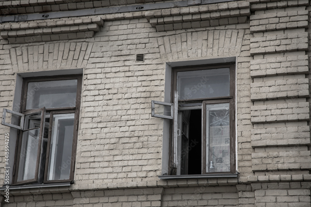 Fototapeta premium Open window on the facade of an old house. Shabby brick wall. Old dirty window. Ancient architecture.