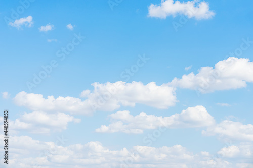 Panorama of delicate blue sky with soft puffy white clouds, summer day sunlight