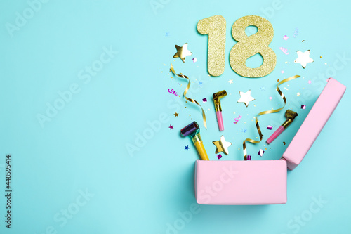 Flat lay composition with decor and numbers on light blue background, space for text. 18th birthday party photo