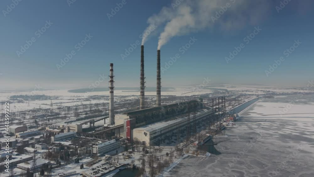 Aerial view of high chimney pipes with grey smoke from coal power plant. Production of electricity with fossil fuel. Aerial view of high chimney pipes with grey smoke from coal power plant. Production of electricity with fossil fuel.