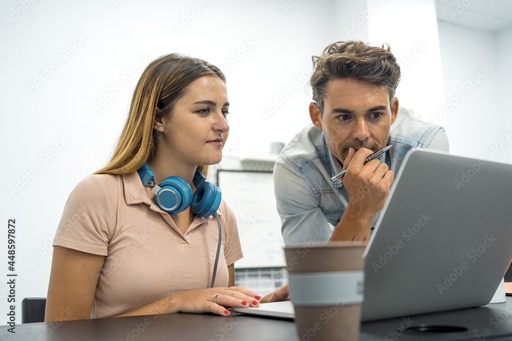 focused young beautiful woman working at desktop with laptop focused young beautiful woman working at desktop with laptop