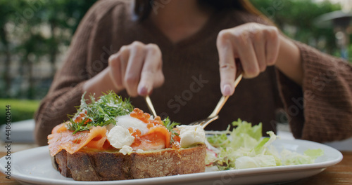Woman eat salmon toast at outdoor cafe