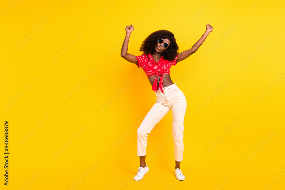 Full size photo of nice optimistic brunette lady dance wear red top trousers isolated on yellow color backgound Full size photo of nice optimistic brunette lady dance wear red top trousers isolated on yellow color backgound