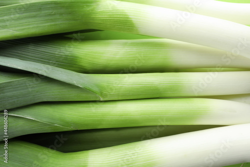 Fresh raw leeks as background, top view