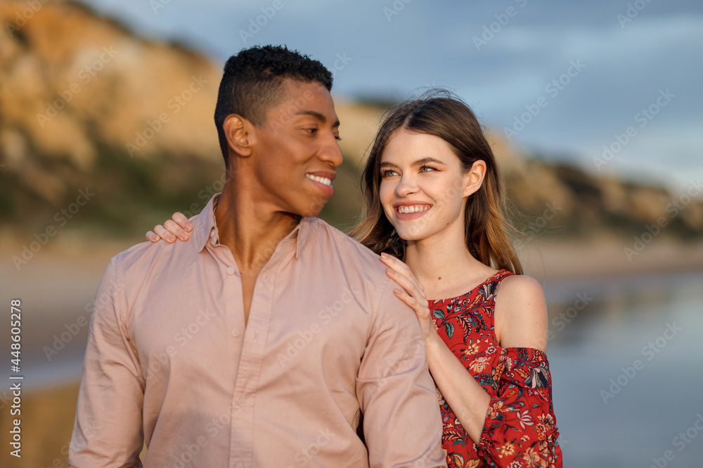 Tender multiethnic couple embracing on beach Tender multiethnic couple embracing on beach