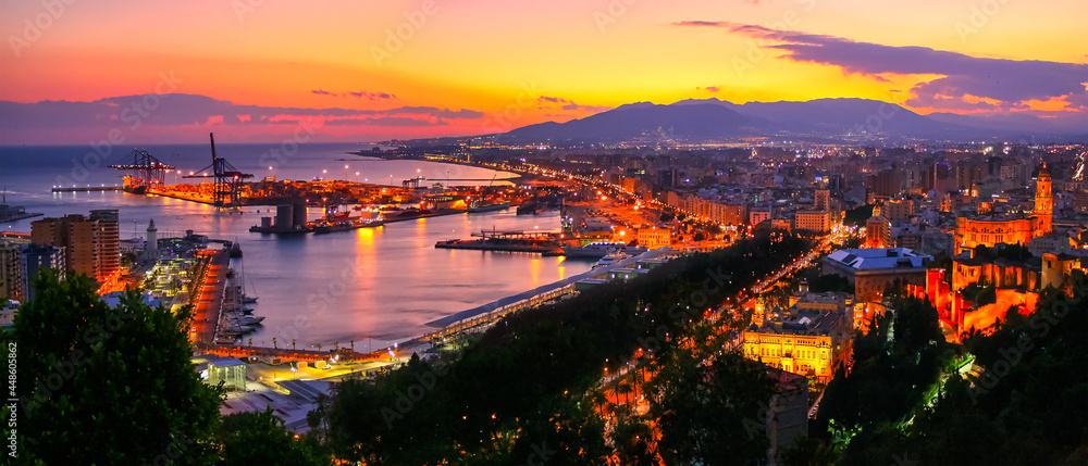 Fototapeta premium Aerial view of the city of Malaga at sunset with warm colors and city lights.