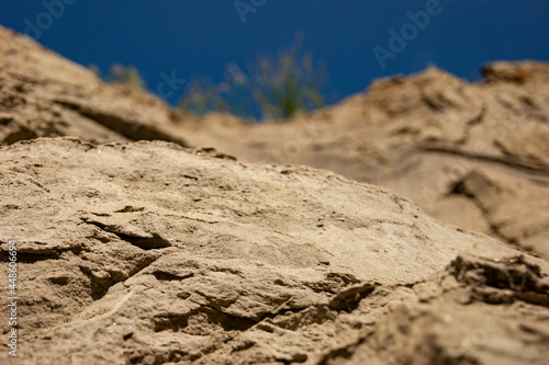 Sand cliffs against the blue sky. Bright sand texture.