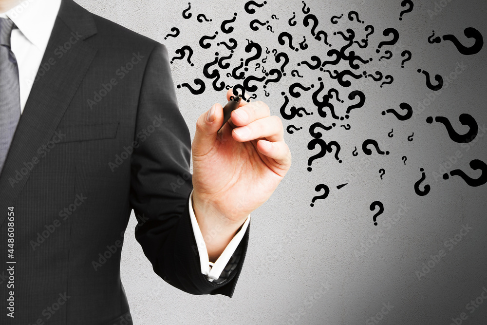 Businessman hand drawing abstract question marks on concrete wall background. Solution, faq and answer concept. Businessman hand drawing abstract question marks on concrete wall background. Solution, faq and answer concept.