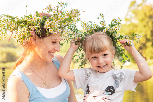portrait of mother with daughter in chamomile wreath © phpetrunina14