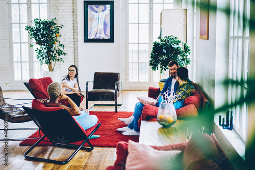 Canvas Print Young male and female best friends resting in modern designed apartment communic