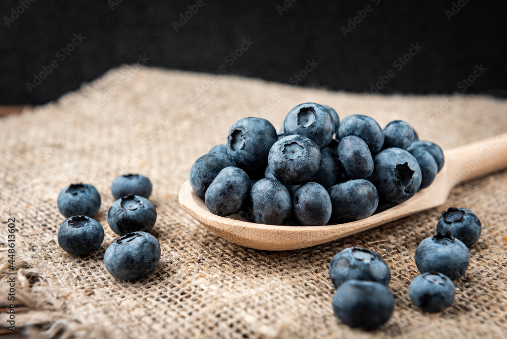 Blueberry in wooden spoon on dark wooden background. Blueberry in wooden spoon on dark wooden background.