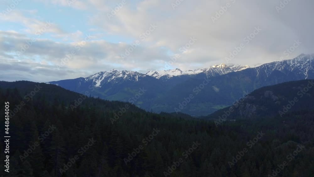 Snowy mountain peaks and fly over green pine forest in Canada Snowy mountain peaks and fly over green pine forest in Canada