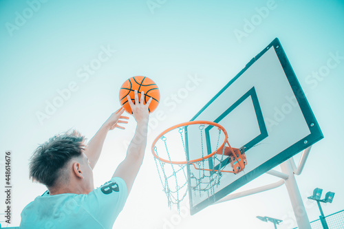Jugador de baloncesto canastando el balón en la pista de juego para ganar puntos photo
