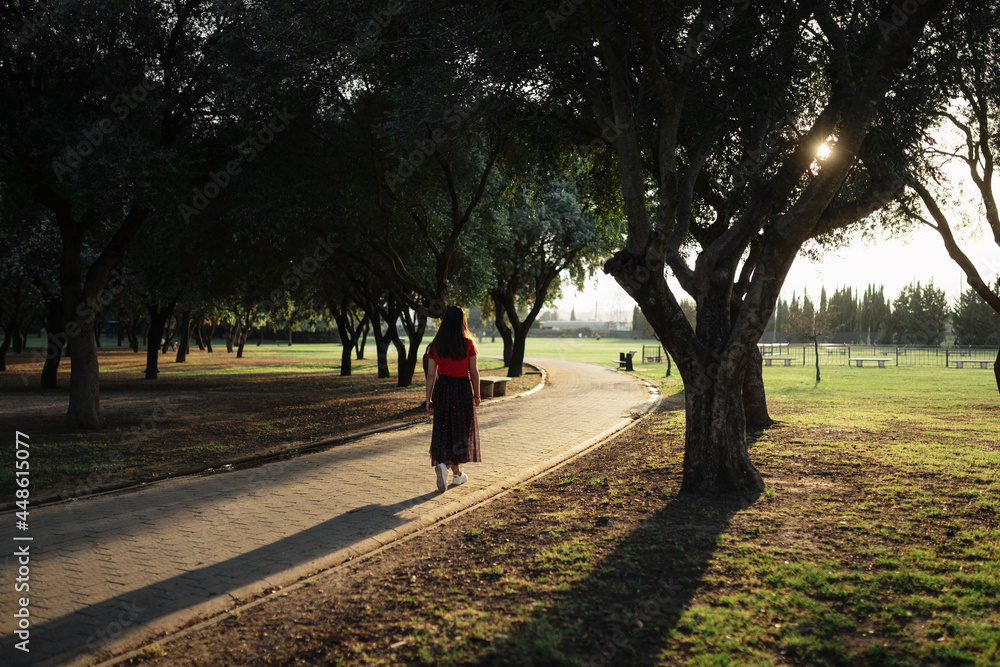 Stylish woman standing on path meadow in park Stylish woman standing on path meadow in park