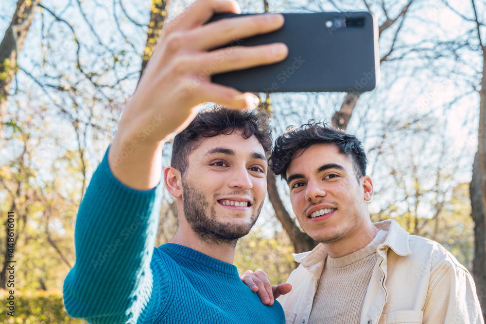 Happy gay couple taking selfie on smartphone Happy gay couple taking selfie on smartphone