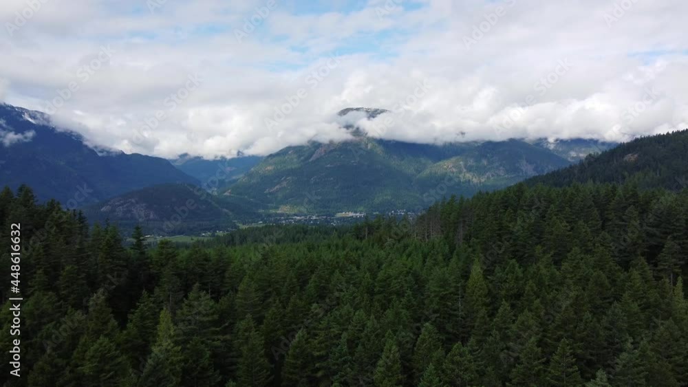 Aerial view of valley in British Columbia with green forest and mountains around Aerial view of valley in British Columbia with green forest and mountains around