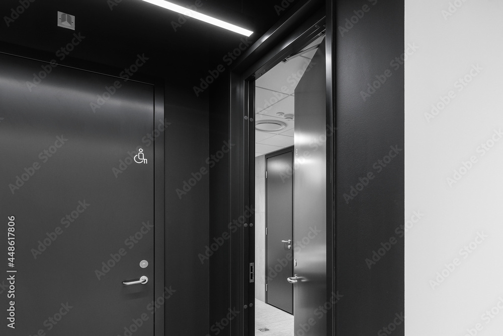 Interior of a modern public restroom with grey clay tiles and anthracite doors