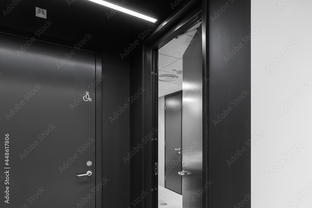 Interior of a modern public restroom with grey clay tiles and anthracite doors Interior of a modern public restroom with grey clay tiles and anthracite doors