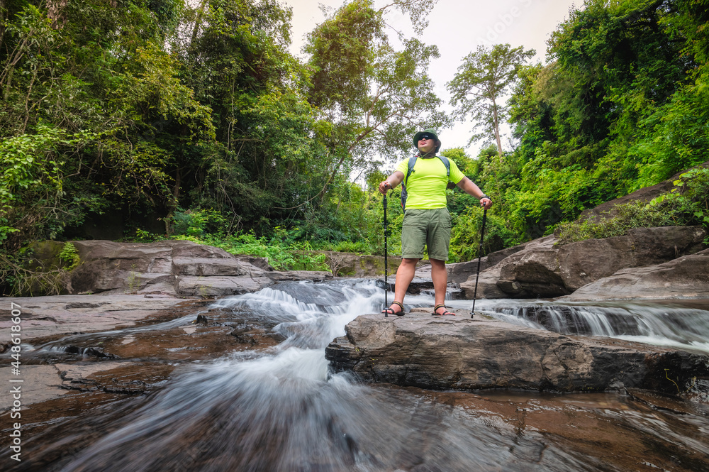 Tourist Travelers with backpack to travel Waterfall in Khao Yai National Park, Thailand UNESCO World Heritage Area. tourist trekking to waterfall in tropical forest during holiday. Holiday activities.
