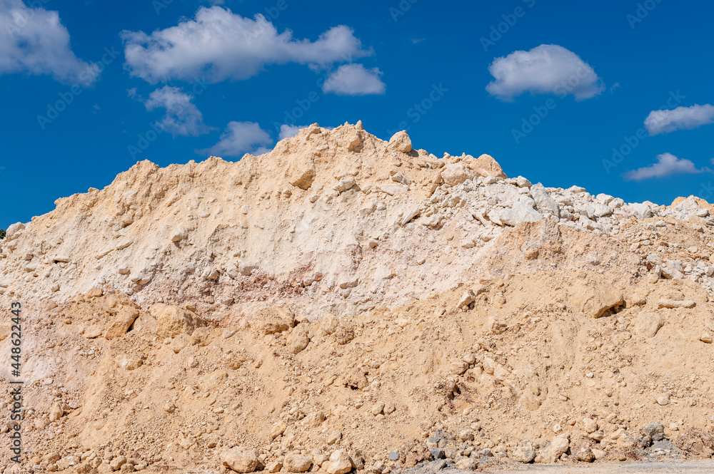 Pile of limestone against blue sky.