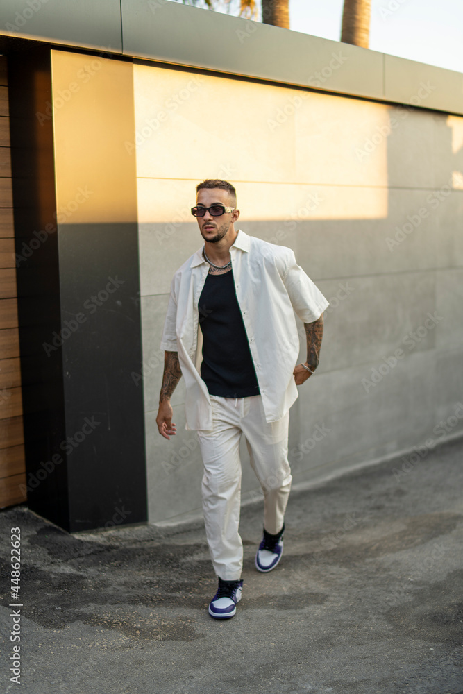 Chico joven atractivo vestido a la moda frente a puerta de garaje