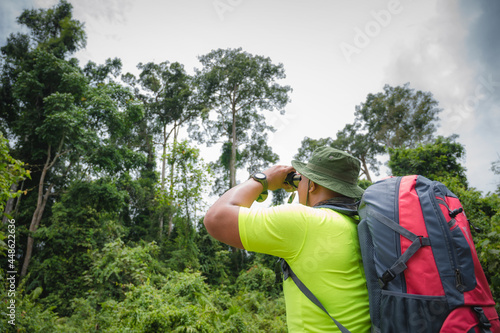 Tourists watching bird hornbill and monkey with binoculars in the tropical forest. Khao Yai National Park, Thailand. Bird, hornbill And Monkey watching tour. Image of the concept of eco-tourism.