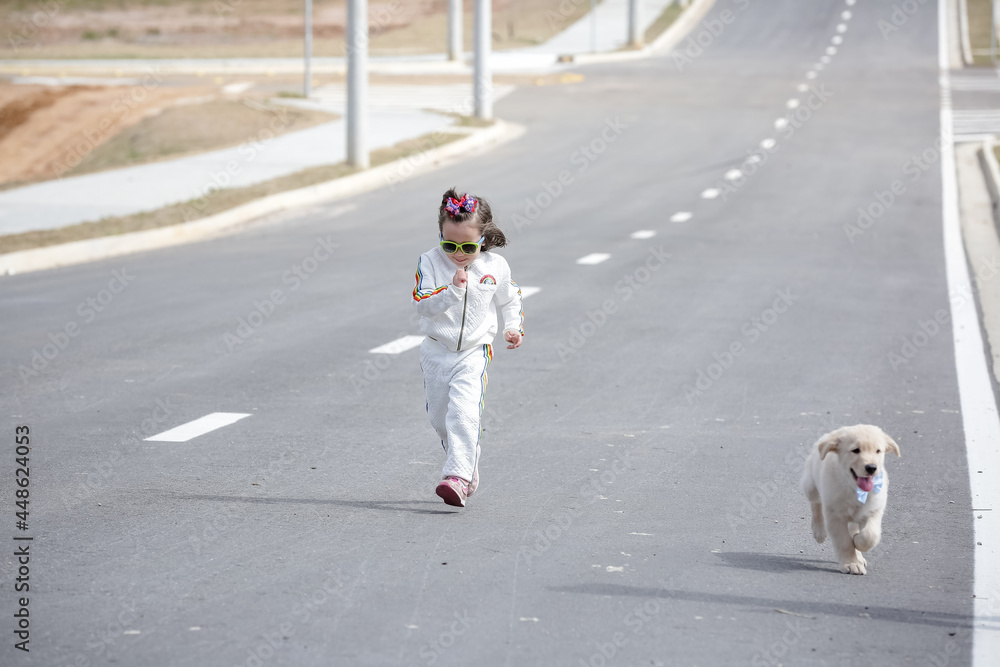 Linda criança com roupa branca e óculos de sol brincando com cachorro Golden Retriever .
Linda criança com roupa branca e óculos de sol brincando com cachorro Golden Retriever .