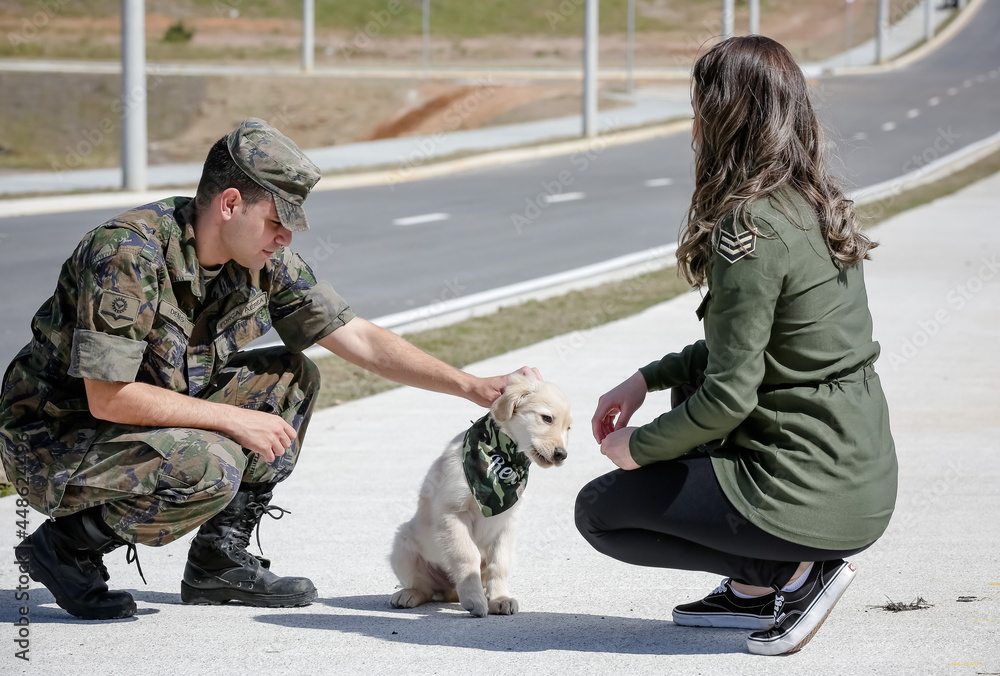 Casal passeando com cachorro Golden retriever com roupa militar retro.