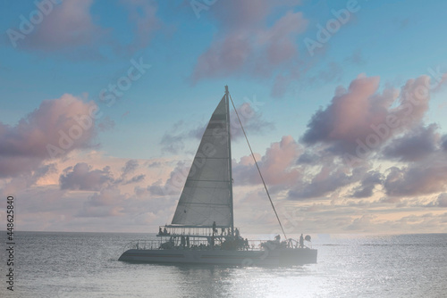 Yacht sailing - silhouette of a Catamaran in the Caribbean Ocean at sunset, island of Cozumel, Mexico © Marco B.