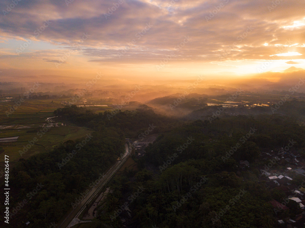 Drone photo of the Indonesian rural landscape with river and forest in the morning on foggy weather Drone photo of the Indonesian rural landscape with river and forest in the morning on foggy weather
