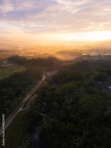 Drone photo of the Indonesian rural landscape with river and forest in the morning on foggy weather © MdzFahmi