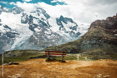 Bench among snow mountains. Zermatt, Swiss Alps. Adventure, hiking in Switzerland, Europe. Place for loneliness, silence and relax.