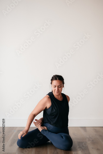 woman holding yoga pose against white backdrop 