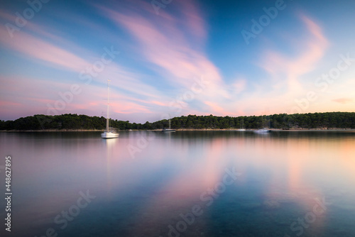 Fototapeta Naklejka Na Ścianę i Meble -  Boats at the bay of Eufemija on island of Rab Croatia with long exposure clouds in the sky