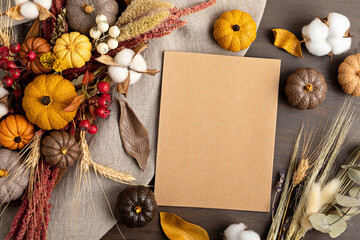 Rustic mockup with autumn table decoration.  Floral interior decor for fall holidays with handmade pumpkins. Holiday greeting card. Flatlay, top view.