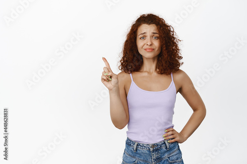 Not so fast. Skeptical redhead stylish girl shaking finger, grimacing disappointed, dislike and reject something, decline offer, prohibit, standing over white background