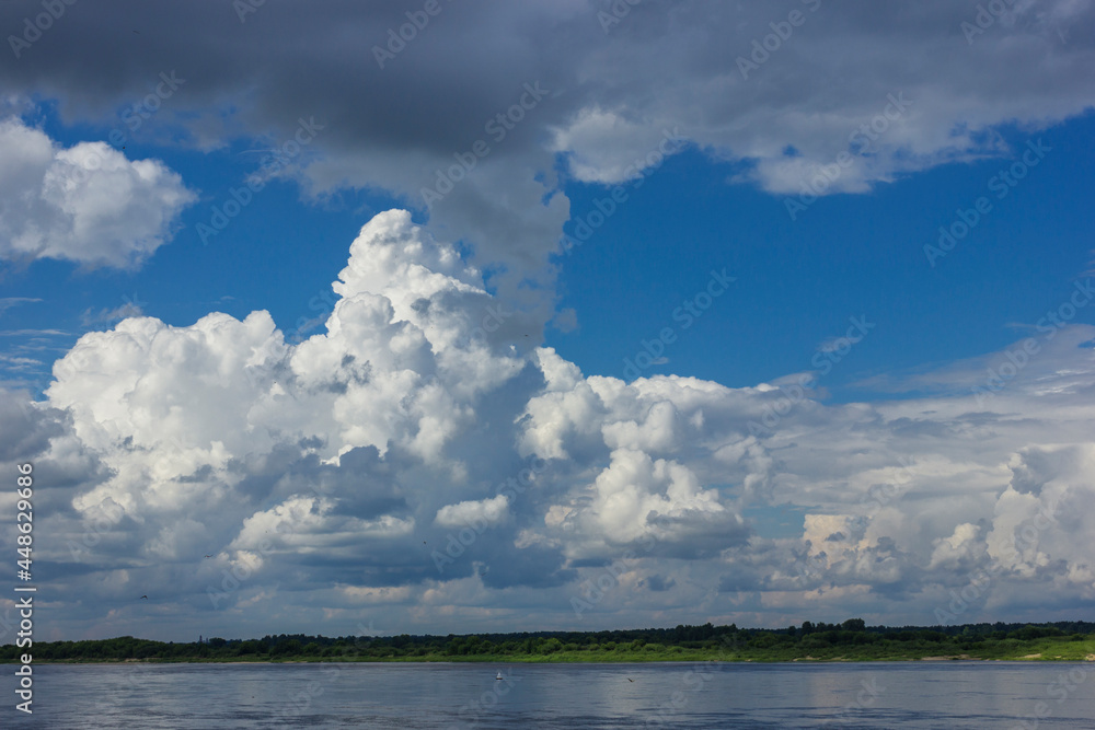 Powerful clouds over the bed of a large river in summer Powerful clouds over the bed of a large river in summer